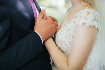 Obraz na płótnie Canvas Lovers hold hands. Newlyweds. Wedding. A man holds a woman's hand.Romance.