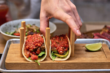 Traditional street mexican pork tacos with beef, tomatoes, avocado, chilli in yellow corn tortilla