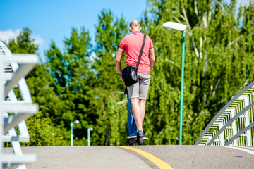 Man rides an electric scooter in the summer Park
