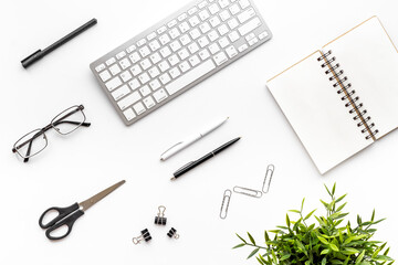 Flat lay office workspace with keyboard and office supplies, top view