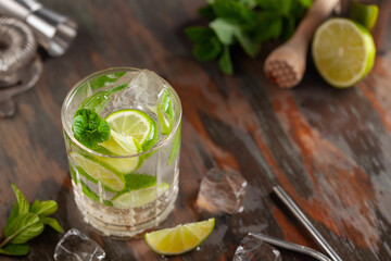 Mojito cocktail with lime and mint in glass on a grey background