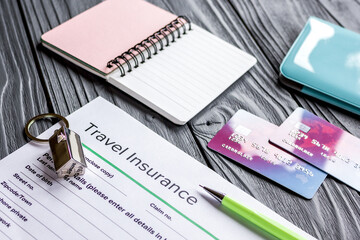 Traveling concept with insurance application and passport on wooden table
