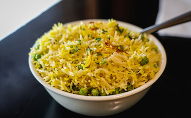 Peas Pulao, a vegan and gluten-free dish made with basmati rice, green peas, spices, and fried onions, served in a white ceramic bowl.