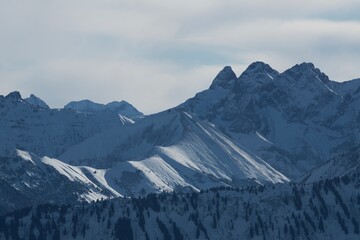Winterliche Landschaft der schneebedeckten bayerischen Alpen vor blauem Himmel im Sonnelicht