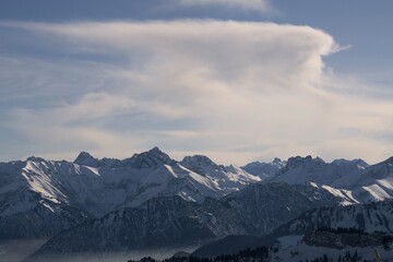 Obraz na płótnie Canvas Winterliche Landschaft der schneebedeckten bayerischen Alpen vor blauem Himmel im Sonnelicht