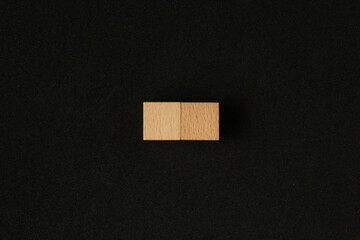 Two wooden cube on black background. Flat lay view concept with a copy space