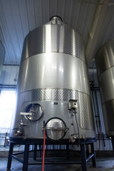 A Large Stainless Steel Commercial Wine Holding Fermentation Blending Tank, Cement Ground, Indoors - Oregon