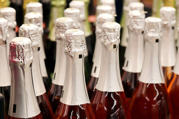 Sparkling wine bottles in a supermarket. Champagne in wine store, alcohol industry