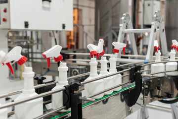 Plastic bottles, sprayers, on the automated conveyor line on the chemical factory. Cleaners...
