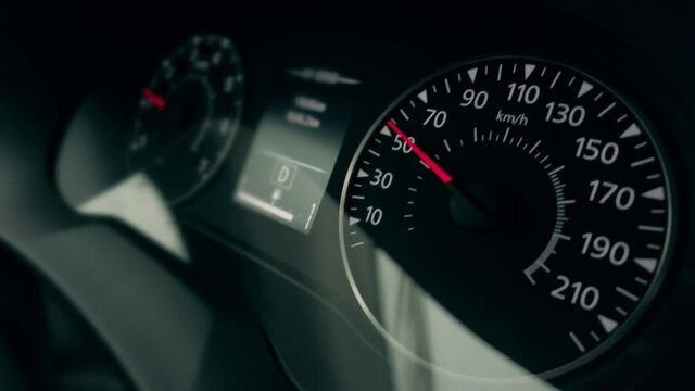 Slowing down car control panel or dash close-up shot