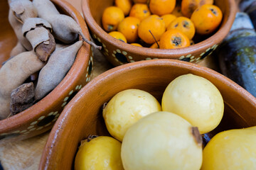 Fresh guavas, hawthorns, and tamarind in clay bowls