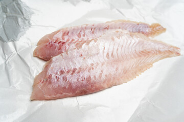 Two fresh redfish fillets on white wrapping paper