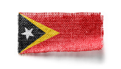 East Timor flag on a piece of cloth on a white background