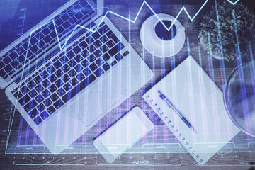 Financial market graph and top view computer on the desktop background. Double exposure. Investment concept.