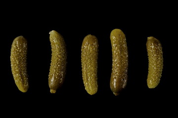 Pickled gherkin pile, pickles set and collection isolated on black background, top view