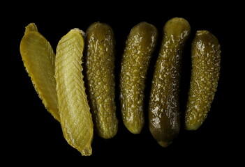 Pickled gherkin pile, pickles isolated on black background, top view
