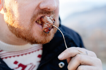 Hungry man eating barbecue stick with meat