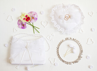 Bride accessories: rings, handbag, boutonnie. Wedding background.