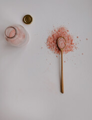 pink salt on the white table in wooden spoon