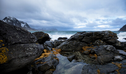 Lofoten Islands. Beautiful landscape. Stones, a red house against the backdrop of mountains and clouds.