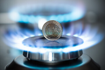 Burning natural gas and one euro coin on gas hob.