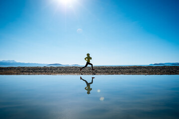 Woman trail runner cross country running in winter lakeside