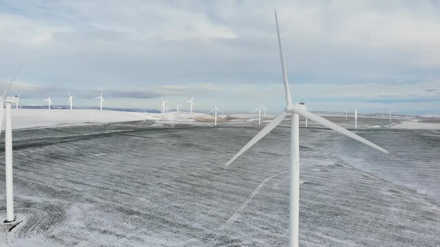 Close Up Row of Wind Turbines on Snowy Field in Oregon - Aerial Drone