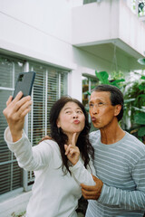 Happy asian senior couple taking selfie with smartphone.