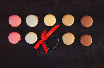 Festive dark background. Heart of sweet candies. Colorful macaroons. Valentine's Day. 14 of...