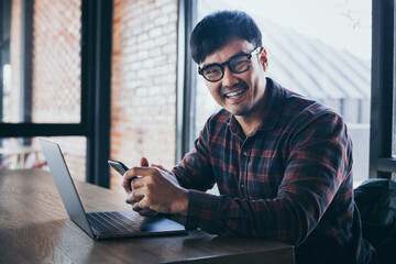 man work using texting cell phone typing computer.student study online learning.chatting on mobile,laptop contact us at Thinking business plan.connecting people concept