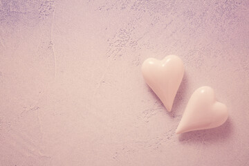 Obraz premium Two glass hearts on stone background in vintage pastel colors