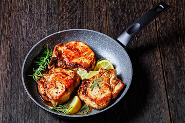 fried pork chops on a skillet, top view