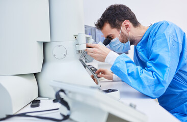 Researcher works on microscope in laboratory during Covid-19 pandemic