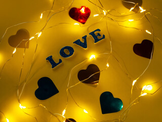 Valentine's Day Love glitter sign text on pastel yellow background hearts confetti, creative flatlay minimal concept. Greeting card top view social media sale banner design. Bright vebrant colors.