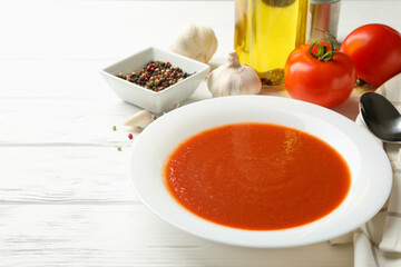 Concept of tasty dinner with tomato soup on wooden background