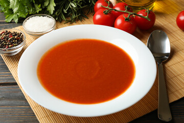 Concept of tasty dinner with tomato soup on wooden background