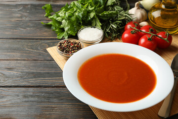 Concept of tasty dinner with tomato soup on wooden background