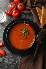 Concept of tasty food with tomato soup on black smokey background