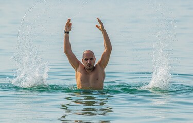 man in the sea raising arms