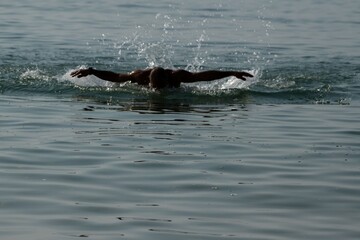 Obraz premium man swimming in the sea towards the camera