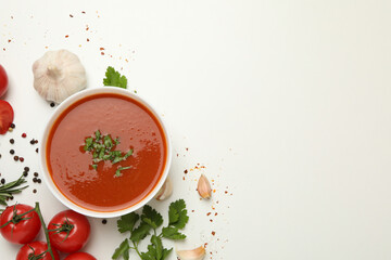 Bowl with tomato soup and ingredients on white background