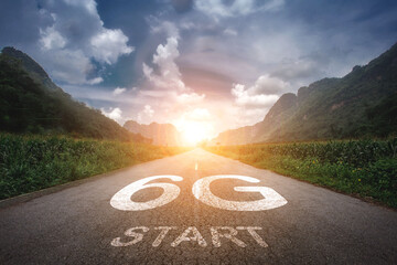 6G or the beginning of technology The concept of 6G is written on a road in the middle of an asphalt road with a mountain backdrop, sunset, planning ideas and challenges.