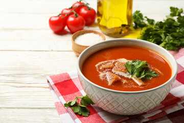 Concept of tasty food with tomato soup on wooden background
