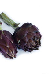 Fototapeta premium Fresh raw artichokes isolated on a white background. Cut Cynara scolymus 