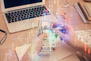 Multi exposure of financial graph drawing hologram and USA dollars bills and man hands. Analysis concept.