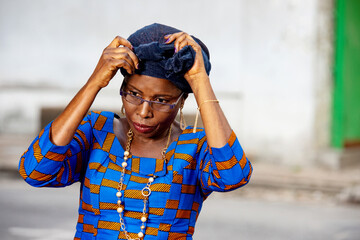 beautiful adult businesswoman tying a scarf on her head.