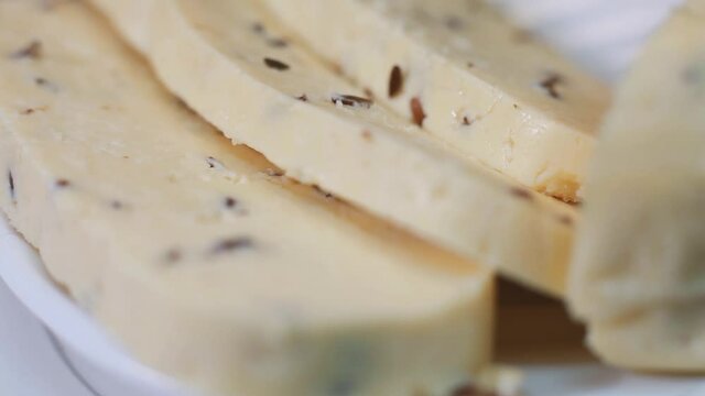 Fresh cheese with cumin. Cumin sprinkled on cheese. The tray rotates. Selective focus