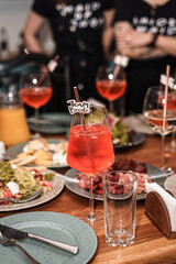 On the served table there is a cocktail  for a bachelorette party. In the background are figures of girls.