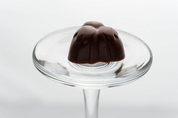 Closeup shot of a single chocolate piece placed on a small glass bowl