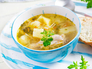 Chicken soup with noodles and vegetables in bowl.